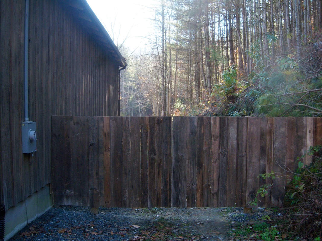 Picture of a driveway gate next to a barn