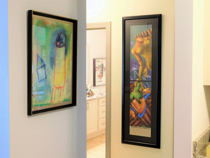 Picture of two paintings hung near a kitchen