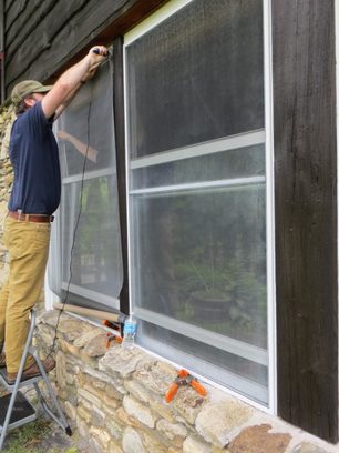 Handyman replacing a window screen